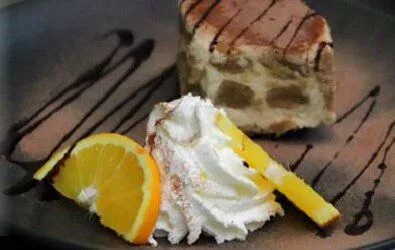 Tiramisu mit Schlagobers, Orangenspalte und Schokoladensauce