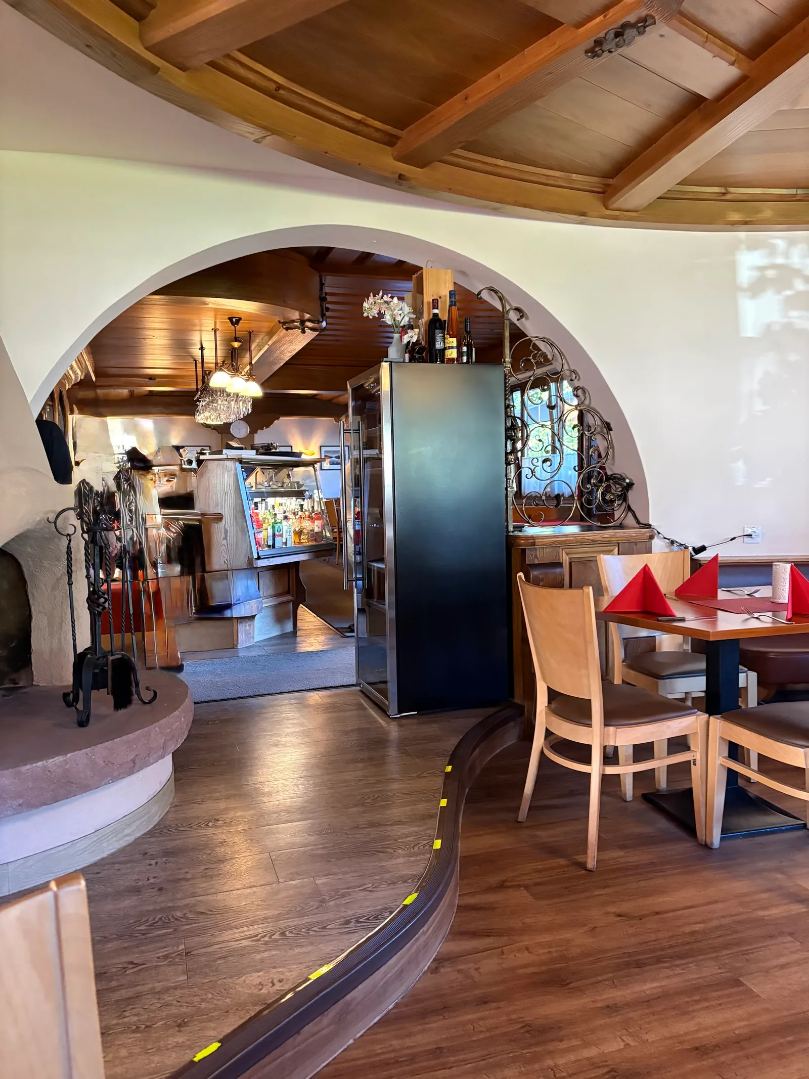 Blick durch den Rundbogen zur Schank, links der gemauerte Kamin